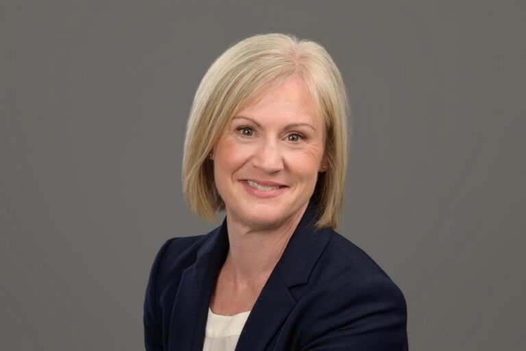 studio headshot of woman on gray background