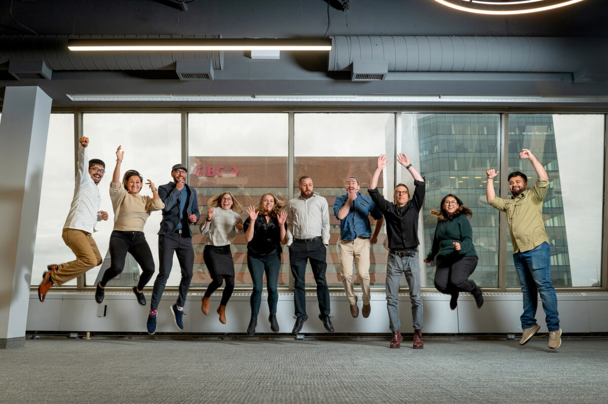 Fun group photo of a group of fun loving people jumping in an office setting