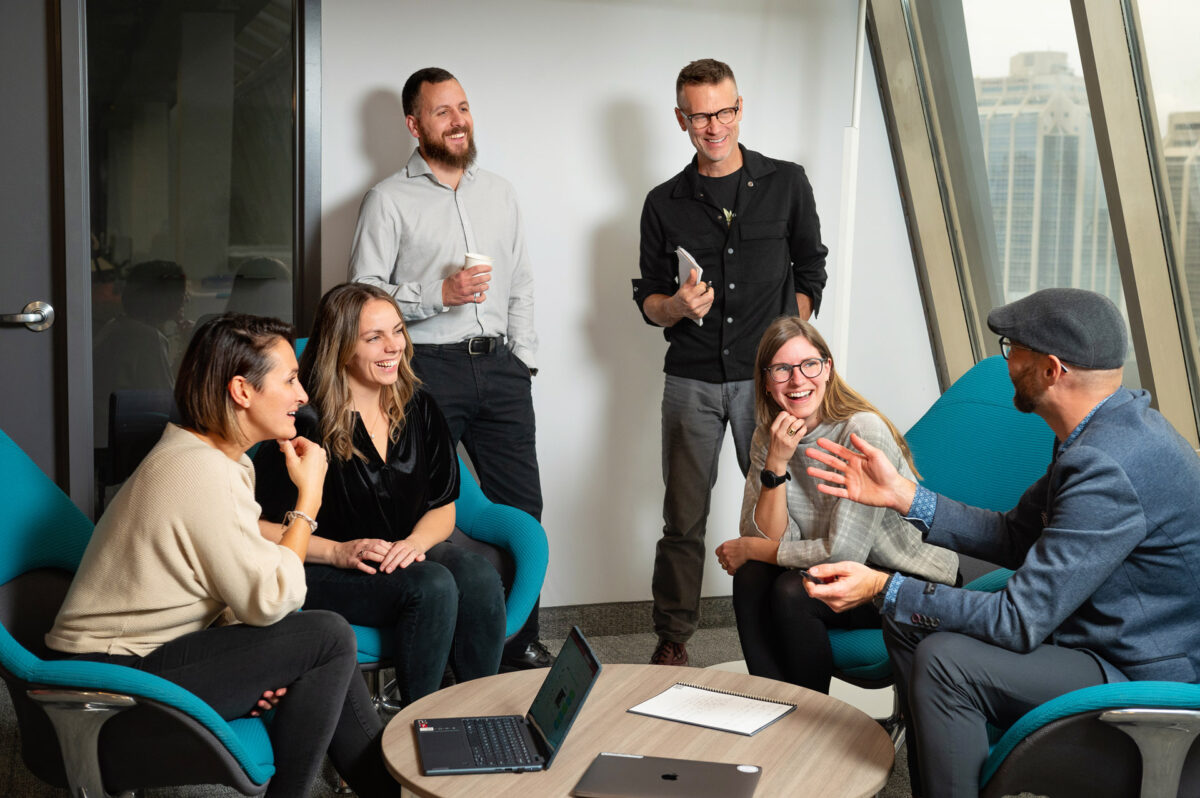 Group photo of laughing people in an office setting